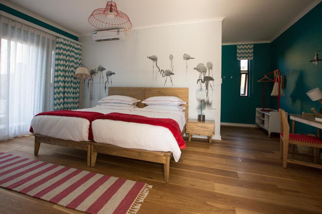 斯瓦科普蒙德斯瓦科普蒙德愉悦酒店的一间卧室配有一张大床和一张书桌