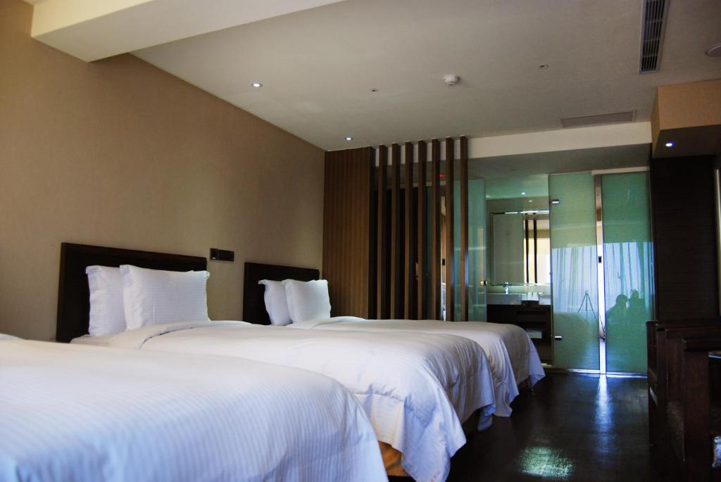 桃园市蜜月世纪大饭店-桃园的酒店客房,配有两张带白色床单的床