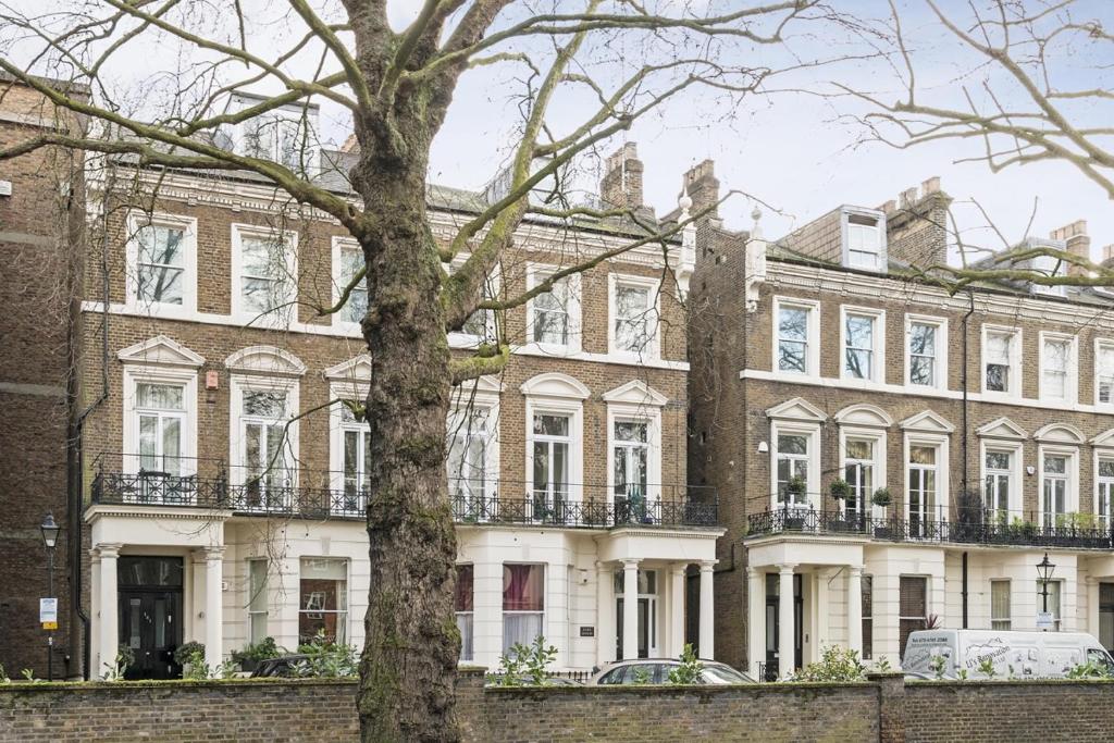 伦敦Holland Park Apartment的前面有一棵树的大房子