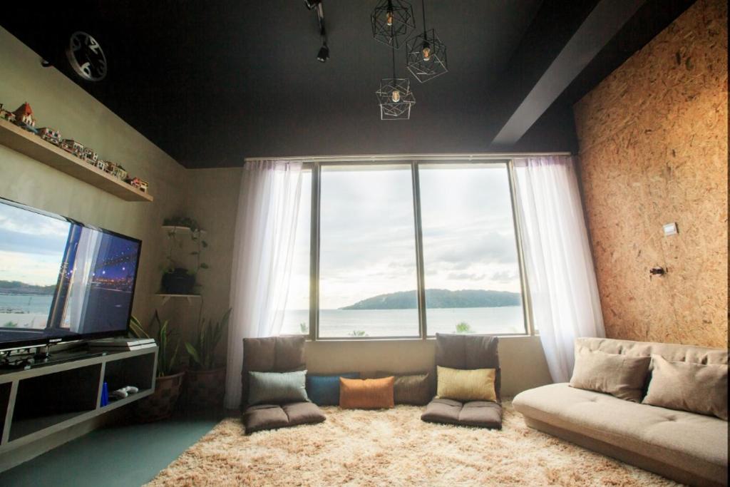 哥打京那巴鲁Homy Seafront Hostel的带沙发和大窗户的客厅