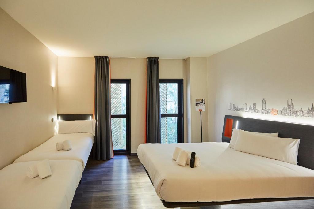 略夫雷加特河畔奥斯皮塔莱特easyHotel Barcelona Fira的有两张床和一扇窗户的酒店房间