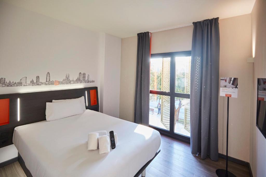 略夫雷加特河畔奥斯皮塔莱特easyHotel Barcelona Fira的卧室里有一张白色的大床和一扇窗户