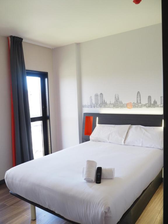 略夫雷加特河畔奥斯皮塔莱特easyHotel Barcelona Fira的卧室里有一张白色的大床，床边有一扇窗户