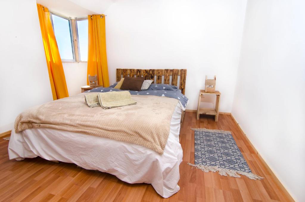 瓦尔帕莱索Mi Paz的一间卧室配有一张床,铺有木地板