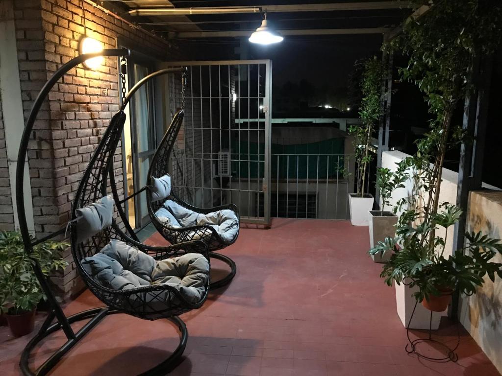 门多萨Alquiler temporario Mendoza的夜晚坐在庭院里的几把椅子