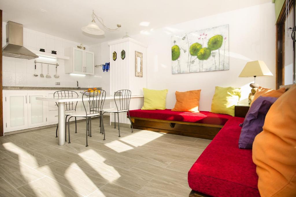 卡门港托佩斯公寓的客厅配有桌子和红色沙发