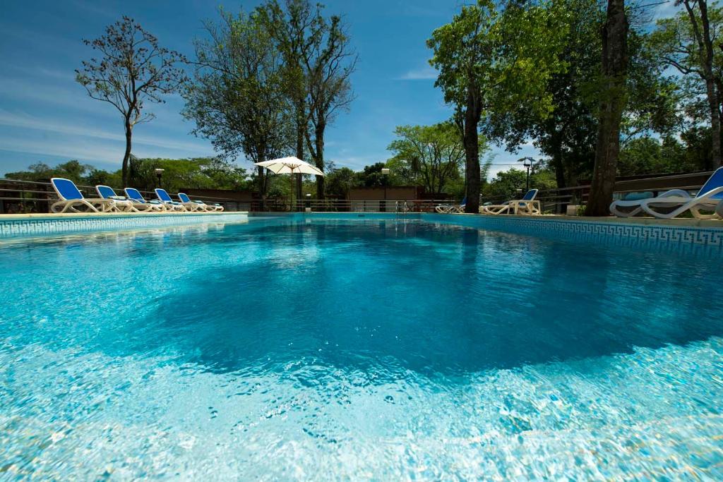伊瓜苏港格兰托比伦酒店的一个带椅子和遮阳伞的大型游泳池