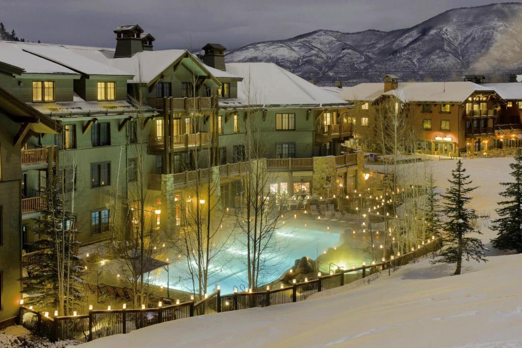 阿斯潘Ritz Carlton, Aspen Highlands的雪地中带游泳池的度假村