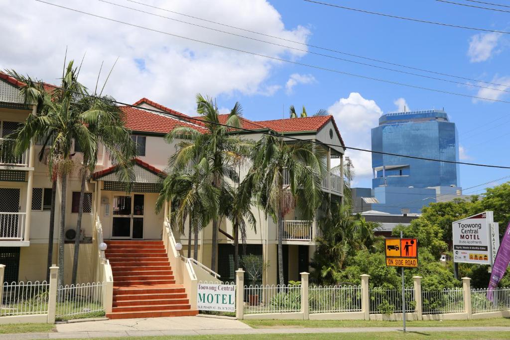 布里斯班图翁中心汽车旅馆式公寓的前面有棕榈树的房子