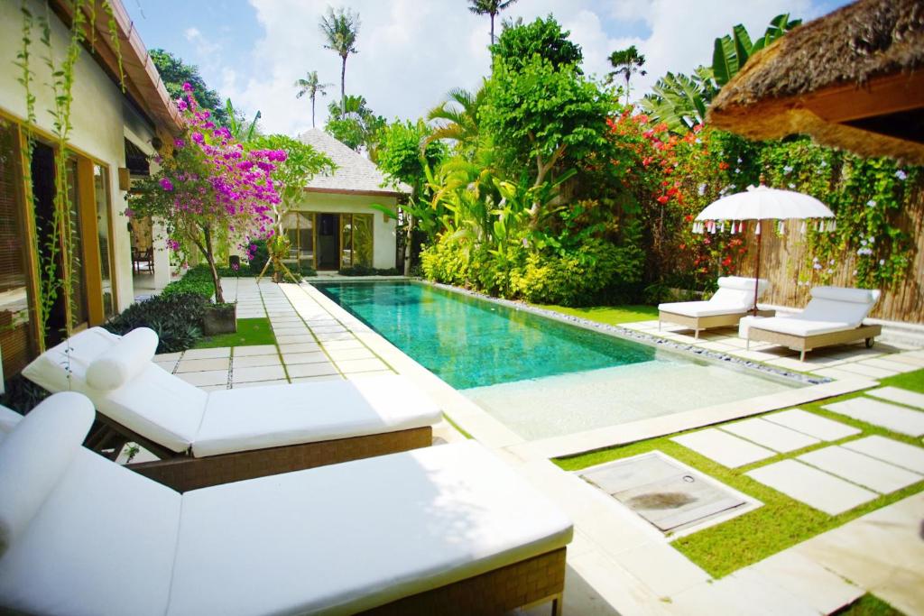 塞米亚克巴厘阿斯里巴图贝里别墅酒店的一个带游泳池和别墅的后院