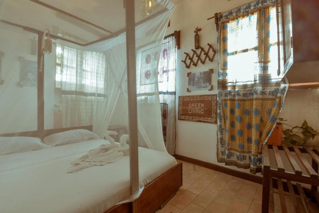 桑给巴尔马林迪旅馆的一间卧室设有两张床和窗户。