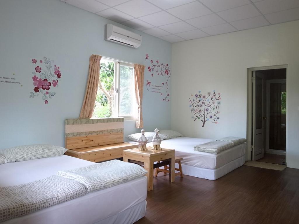 玉里镇加家民宿的客房设有两张床、一张桌子和一扇窗户。