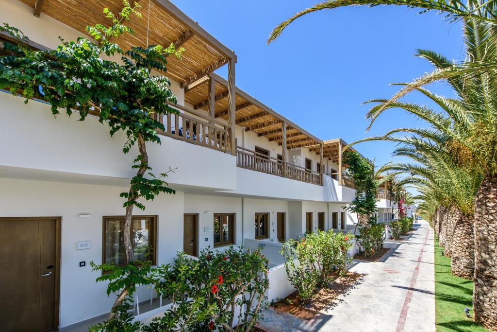 赫索尼索斯Stella Village Seaside Hotel的享有棕榈树建筑的外部景色