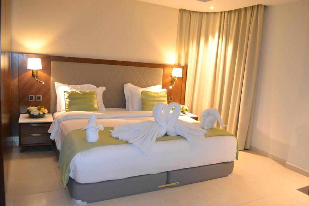 麦纳麦拉米皇宫酒店的一间卧室配有一张大床,床上有毛巾动物
