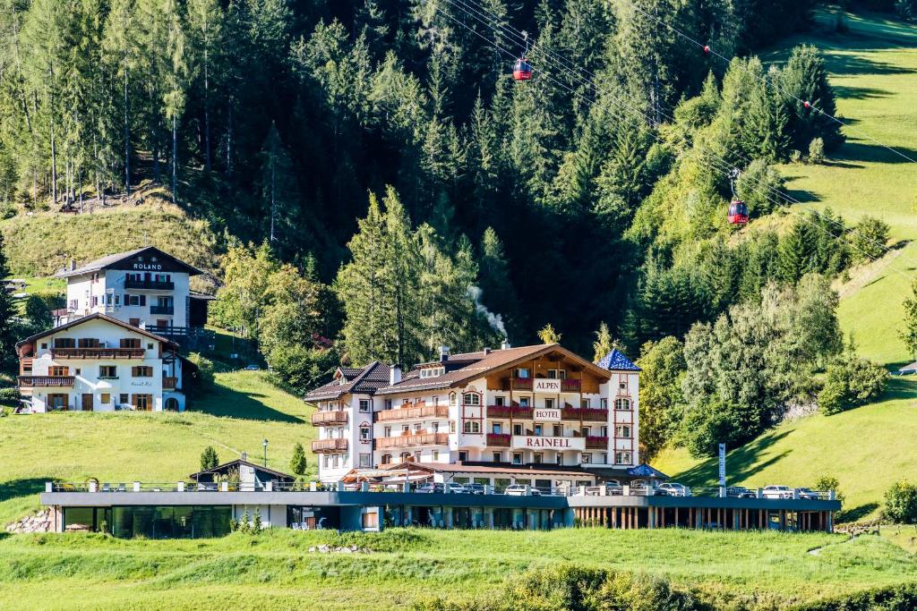 奥蒂塞伊Rainell Dolomites Retreat的绿色田野中的山丘酒店
