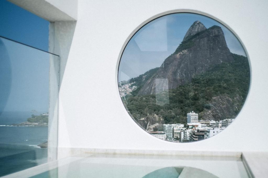 里约热内卢JANEIRO Hotel的享有山景的圆形窗户