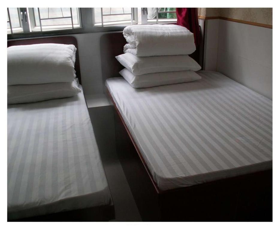 香港龙华賓館的火车上的两张床,配有白色床单和枕头