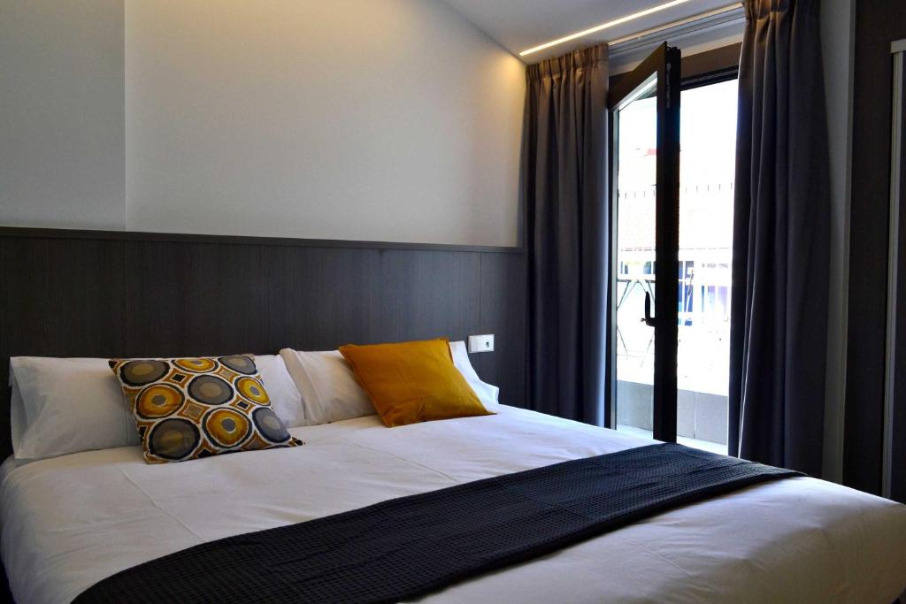 奥伦塞Hotel Alda Estación Ourense的一间卧室设有一张大床和窗户
