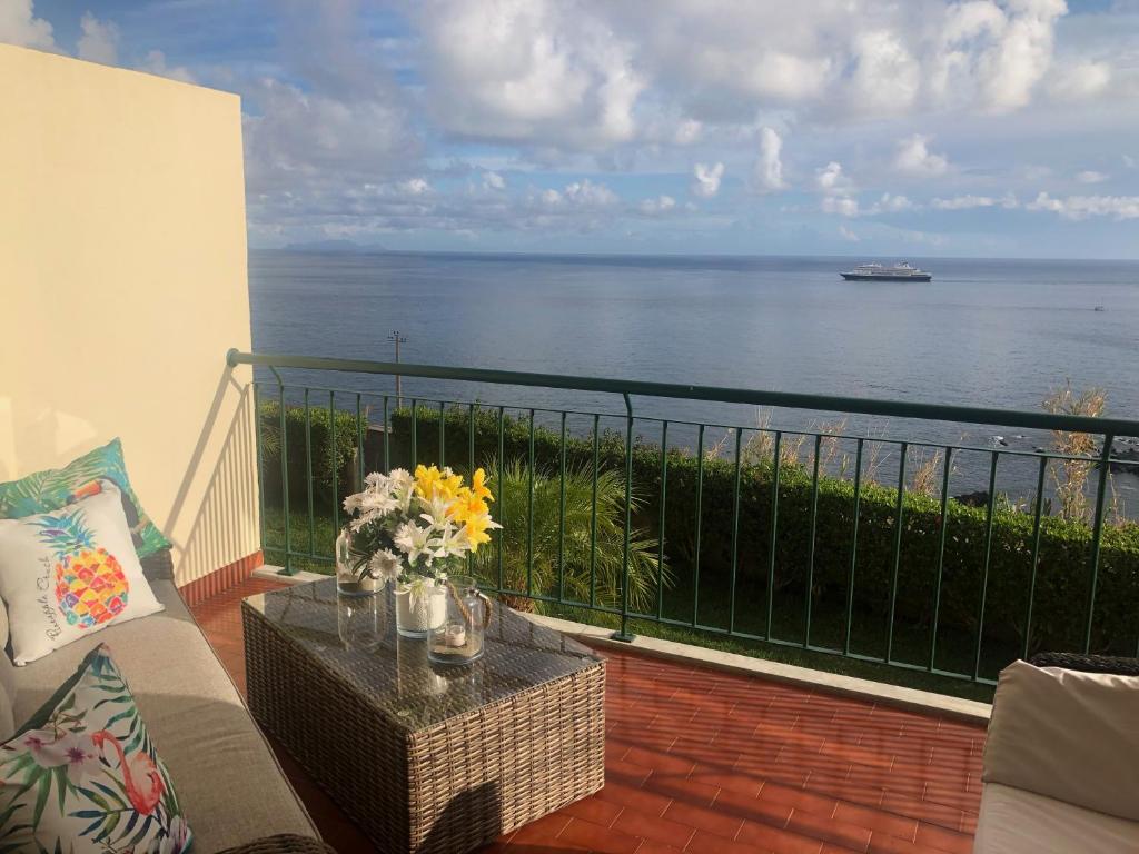 卡尼索Oceanic Apartment的阳台配有沙发,享有海景。