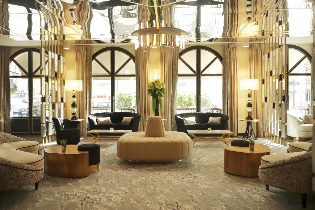巴黎Hôtel le Derby Alma by Inwood Hotels的一个带沙发和椅子的大型大堂以及一个吊灯
