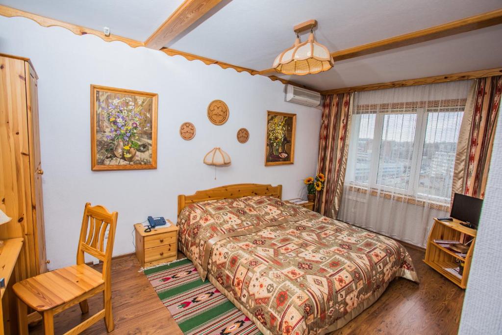 基辅米尔酒店的一间卧室配有一张床、一张书桌和一台电视