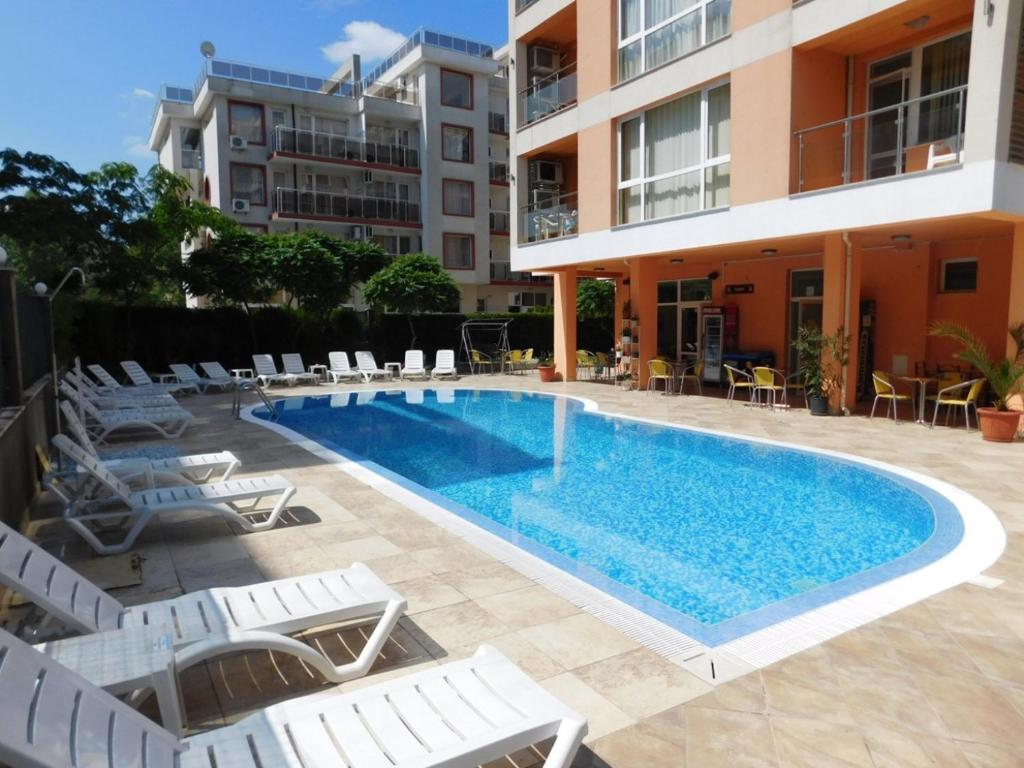 阳光海滩大流士酒店的一座带椅子的游泳池以及一座建筑