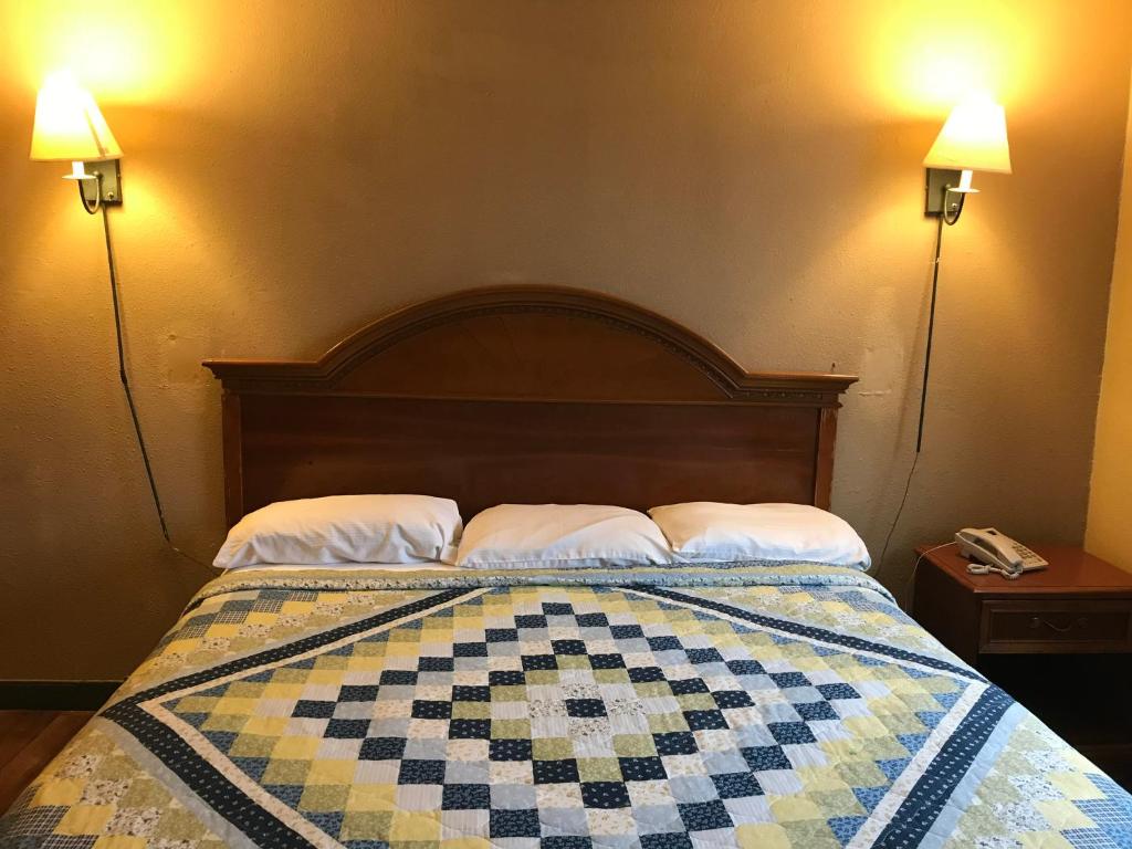 韦恩堡Economy Inn的一间卧室,配有一张带 ⁇ 子被子的床