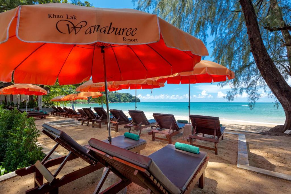 蔻立Khaolak Wanaburee Resort - SHA Extra Plus的海滩上的一组椅子和遮阳伞