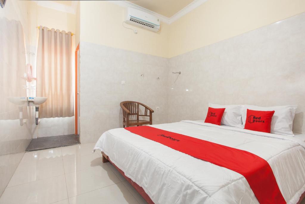 泗水RedDoorz Syariah At Sedati的一间卧室配有一张带红色枕头的大床