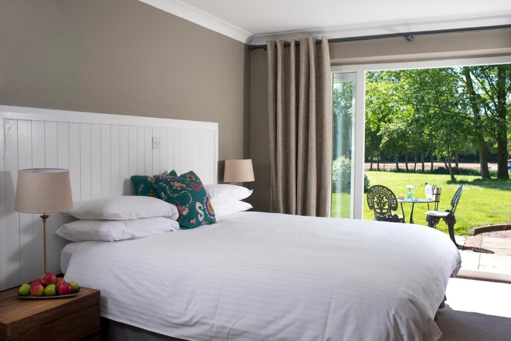奇切斯特Crouchers Hotel的卧室设有白色的床和大窗户