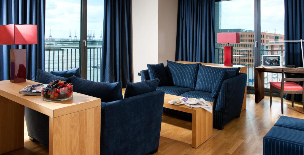 汉堡Clipper Boardinghouse - Hamburg-Holzhafen的客厅配有蓝色的家具和大窗户