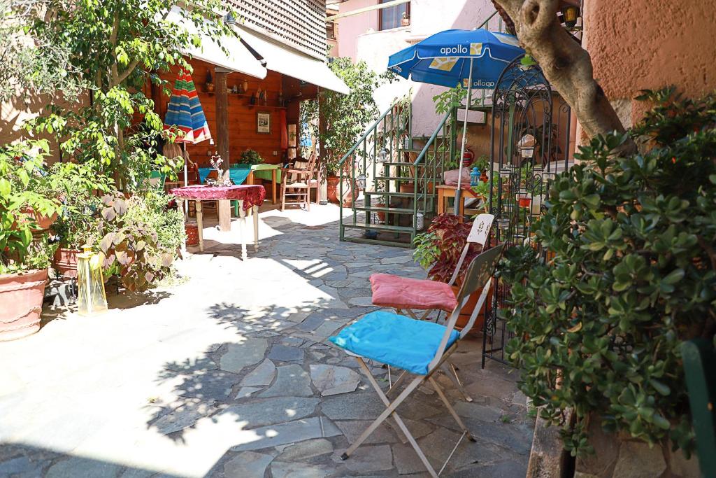 PazinosPazinos Village Studios的庭院里摆放着几把椅子和一把遮阳伞