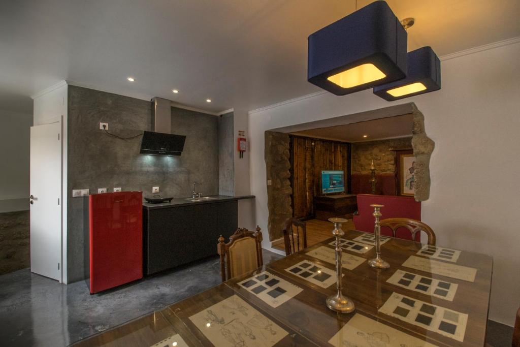 科维良Memórias Charme Residences的厨房配有餐桌和红色冰箱