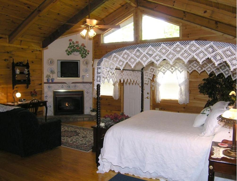 海伦Black Forest Bed & Breakfast的卧室配有白色的床和壁炉
