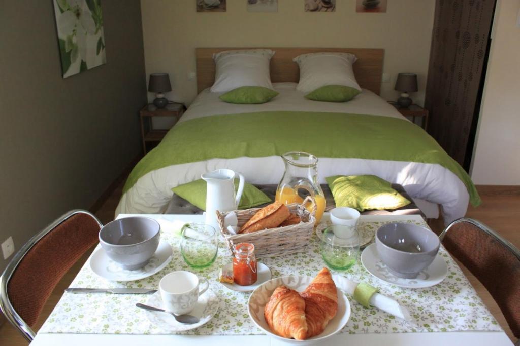 弗雷讷安东尼住宿加早餐酒店的一张桌子,上面放着一篮羊角面包和一张床