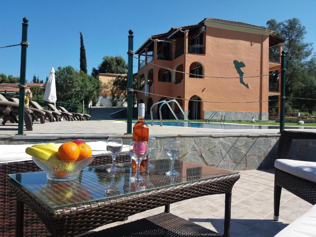 达西亚Ziogas Luxury Apartments的游泳池畔的桌子上摆放着饮料和水果