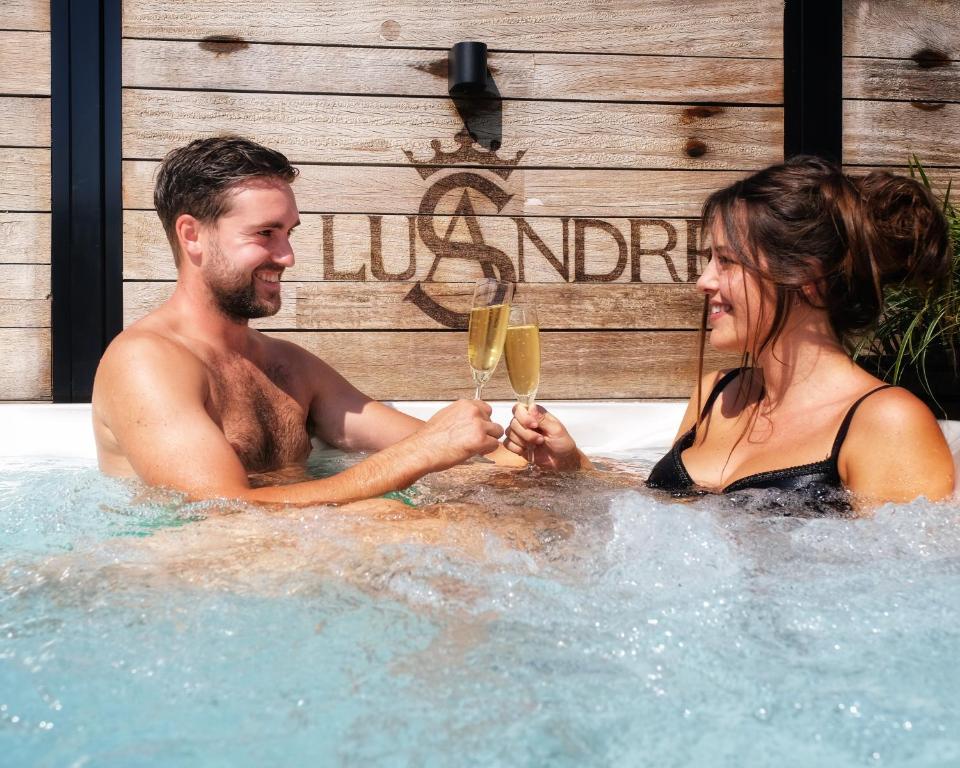 OlenLusandre的男人和女人在带酒杯的热水浴缸中