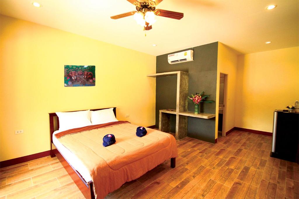 奥南海滩AddJitResort aonang - SHA Extra Plus的一间卧室配有一张床和吊扇