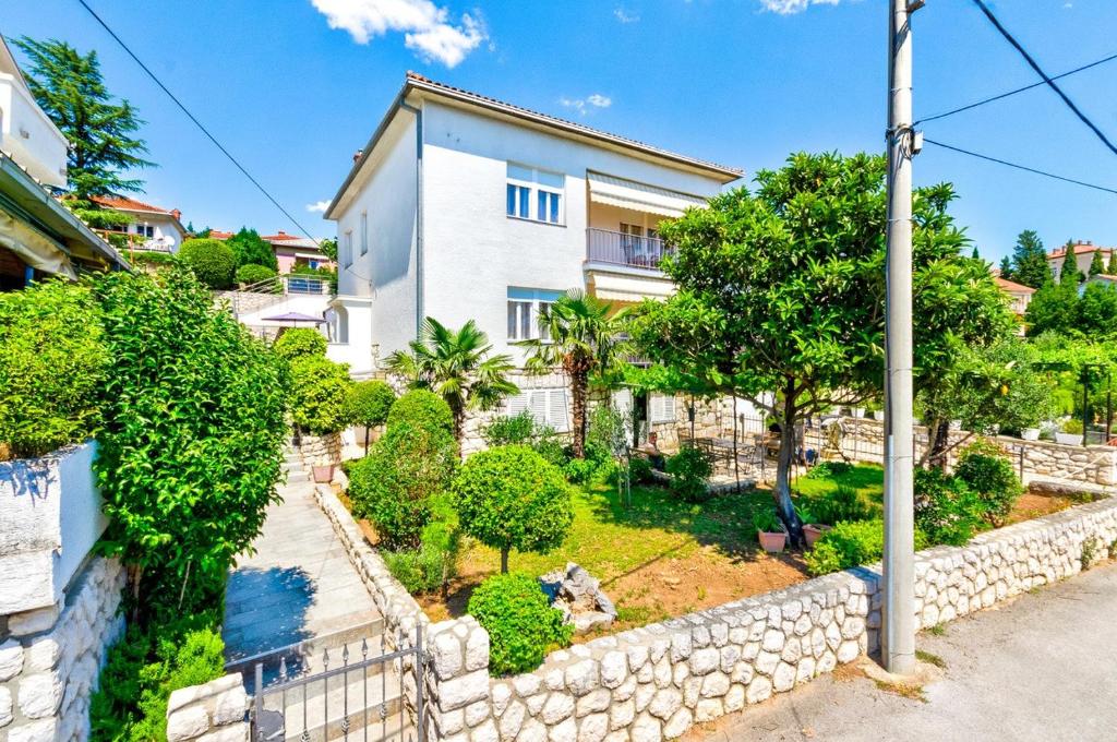 索帕尔茨卡One-Bedroom Apartment in Crikvenica V的一座石墙和树木的房子