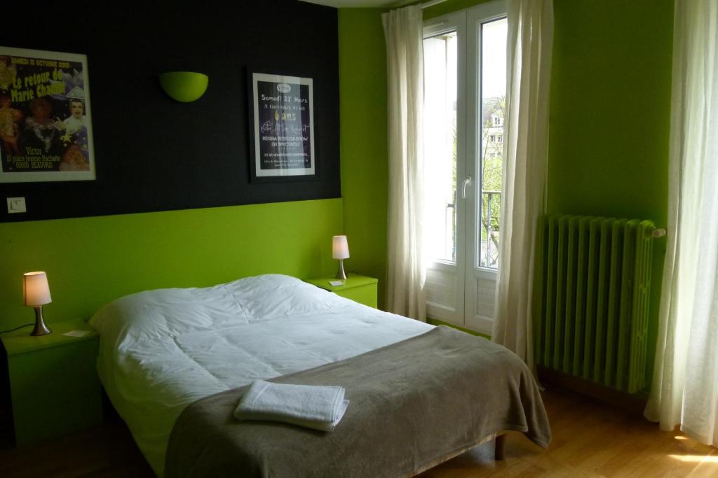 博韦维克多酒店的绿色卧室设有床和窗户