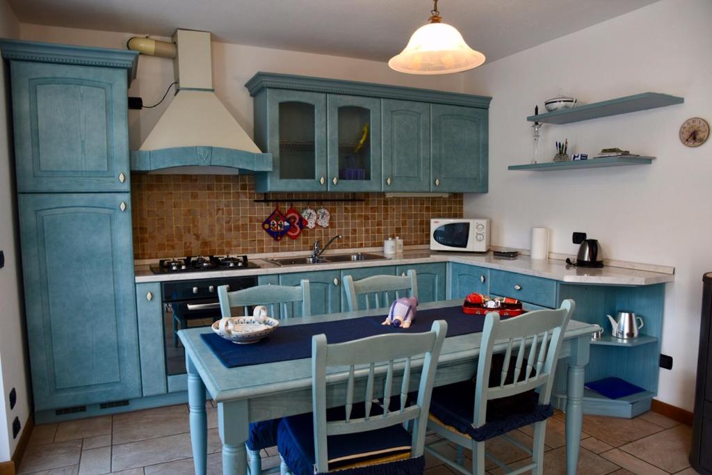 瓦尔迪登特罗Baitin Finferlo的厨房配有蓝色橱柜和桌椅