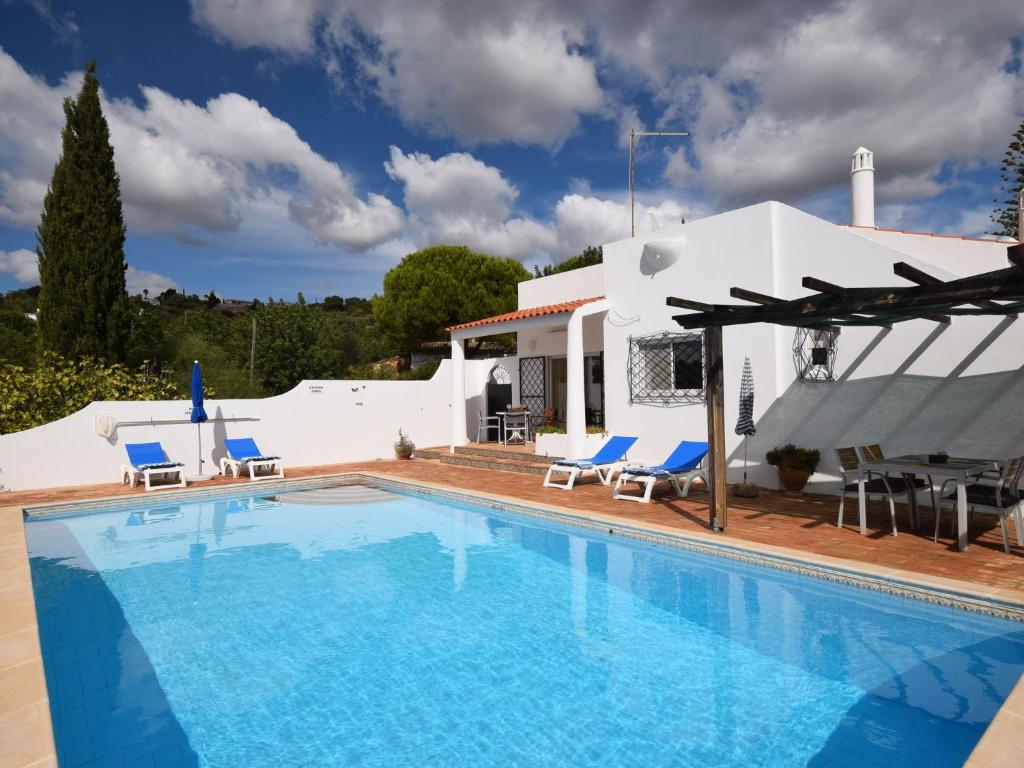 圣巴巴拉-迪内希Secluded villa with a private swimming pool的一个带椅子的游泳池以及一座房子
