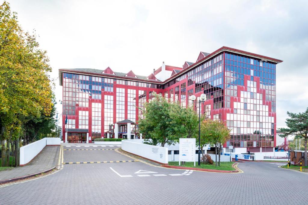 斯劳国敦斯劳温莎酒店的一座大型的红色和玻璃建筑,设有停车场