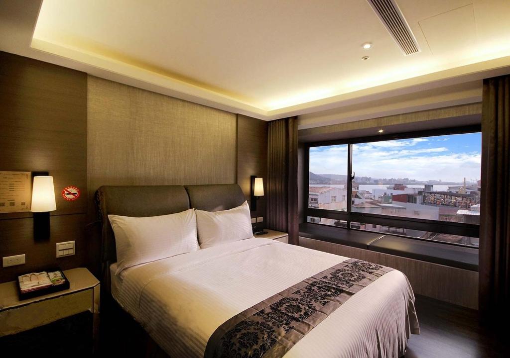 淡水欧朋仑旅店的一间卧室设有一张大床和一个大窗户