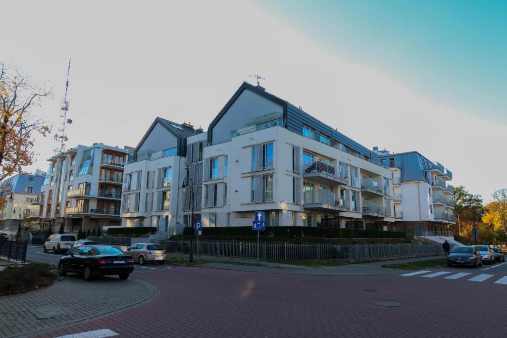 斯维诺乌伊希切Apartamenty Świnoujście - Casa Marina的一条有汽车的城市街道上白色的大建筑