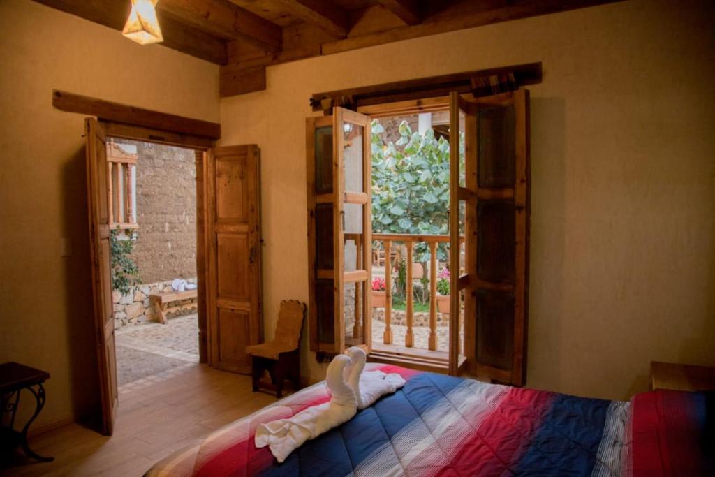 圣克里斯托瓦尔-德拉斯卡萨斯Hotel Casa de Gandhi的一间卧室设有一张床和一个开放式窗户。