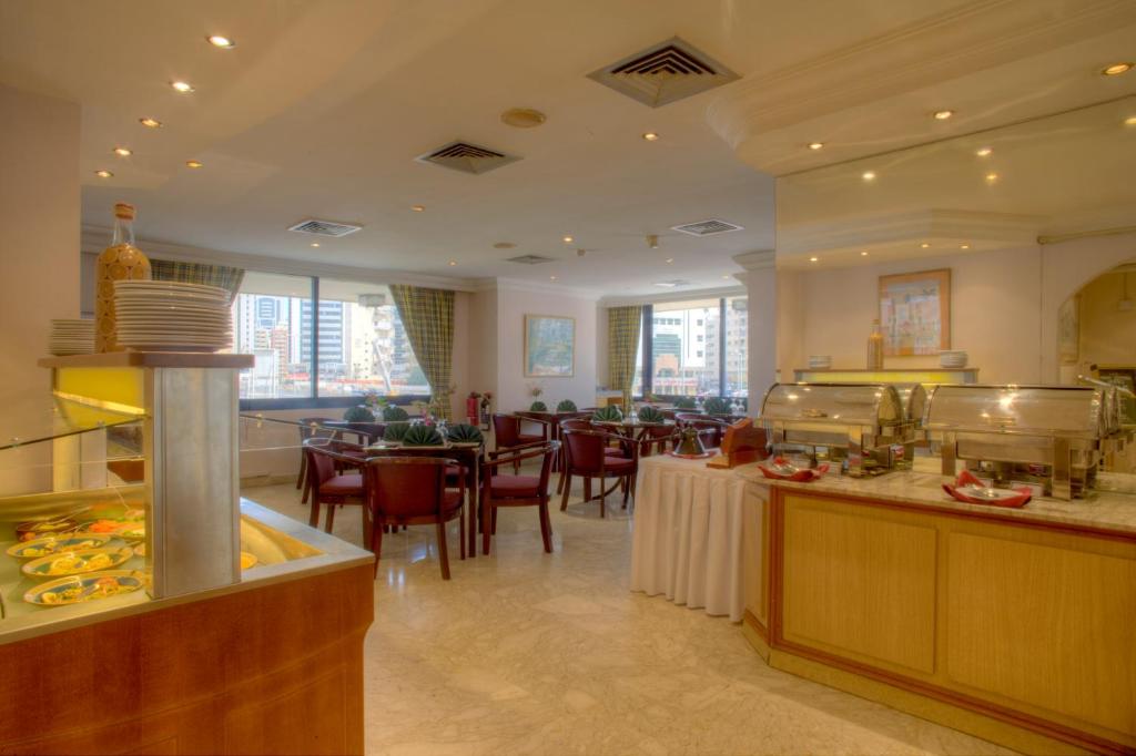 阿布扎比阿尔迪阿米娜酒店的餐厅设有1间带桌椅的自助餐厅