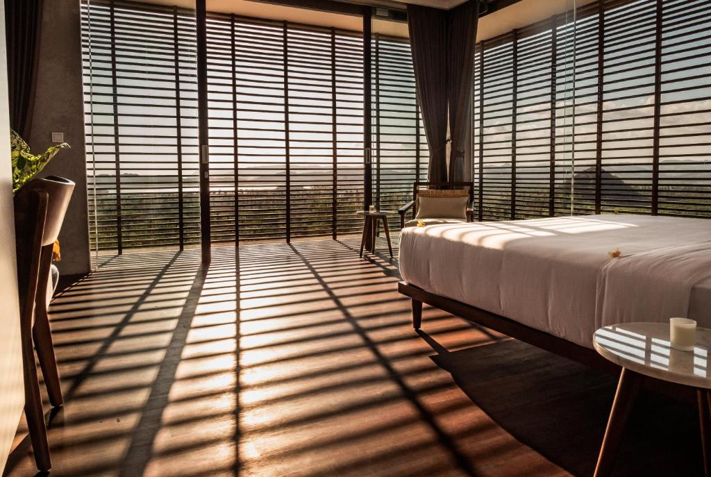 龙目岛库塔Villa Strata的一间卧室配有一张床和一个带百叶窗的大窗户