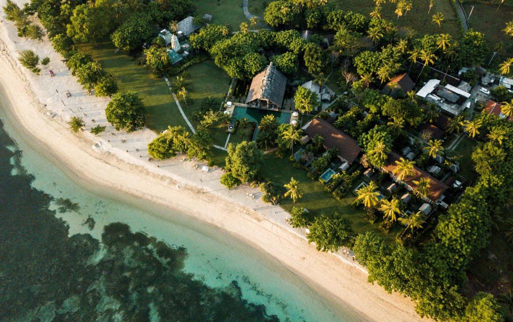 丹戎Hotel Tugu Lombok - CHSE Certified的海滩上的度假村的空中景致