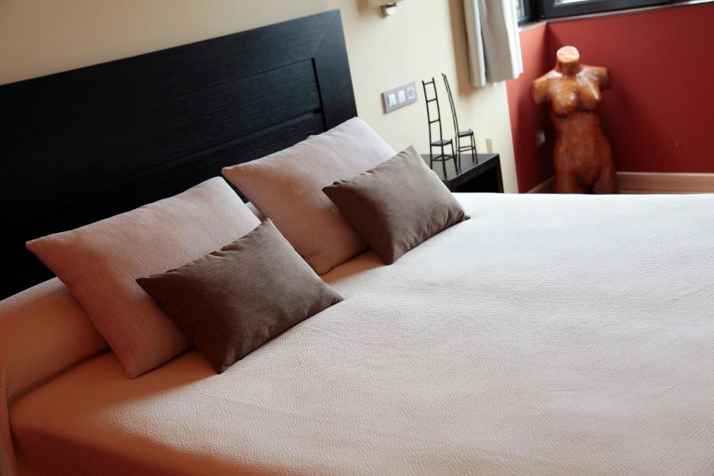 Las Rozas de Valdearroyo阿拉兹酒店的卧室配有一张带两个枕头的大白色床